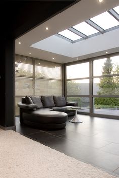 a modern living room with black leather furniture