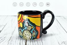 a black coffee mug with colorful designs on it