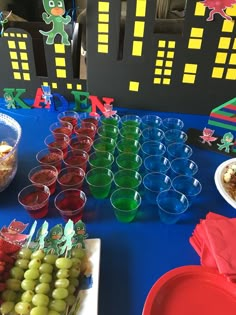 a table topped with plates and cups filled with desserts next to other food items