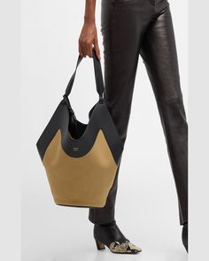 "Find KHAITE Lotus Tote Bag on Editorialist. The Khaite \"Lotus\" tote bag is crafted from leather, canvas cotton, and vegan leather. The bag features a shoulder strap, open top, and an interior, removable zip pouch bag. The bag measures approximately 15.5\"H x 22\"W x 8.5\"D. It is made in Italy." Designer Canvas Shoulder Bag With Large Capacity, Designer Hobo Bag With Leather Handles For Daily Use, Designer Everyday Hobo Tote Bag, Designer Hobo Tote Bag For Everyday, Designer Hobo Bag With Leather Handles For Everyday, Chic Black Canvas Bucket Bag, Chic Coated Canvas Bucket Bag With Handles, Chic Coated Canvas Bucket Bag For Shopping, Elegant Leather Canvas Bag With Large Capacity