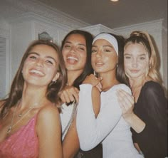 four young women posing for the camera with their arms around each other