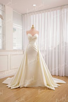 a wedding dress on display in front of a window