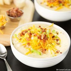 two white bowls filled with soup and topped with cheese