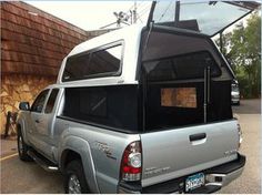 a silver truck parked in front of a building with an awning on it's roof