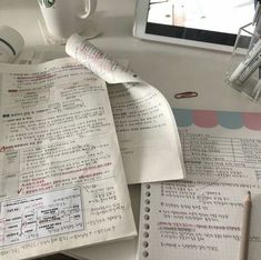 an open book sitting on top of a desk next to a cup