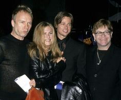 three men and a woman posing for the camera