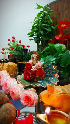 there is a small figurine sitting on a table with flowers and other decorations