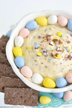 a white bowl filled with candy and marshmallows on top of a blue plate