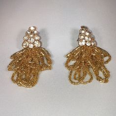 "Gold tone pierced earrings with rhinestones and layered beading. Approximtely 2 1/2\" x 3/4\"" Gold Crystal Earrings With Dangling Beads For Wedding, Festive Gold Beaded Chandelier Earrings, Gold-tone Drop Clip-on Earrings For Parties, Elegant Beaded Metal Crystal Earrings, Gold-tone Beaded Party Jewelry, Gold Dangle Beaded Earrings For Party, Festive Gold Earrings With Gold Beads, Gold Embellished Beaded Earrings For Party, Gold Jeweled Evening Clip-on Earrings