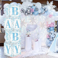 a baby shower is set up with balloons and snowflakes on the wall,