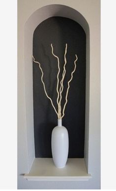 a white vase sitting on top of a shelf