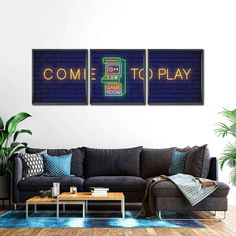 a living room with two couches and a table in front of the wall that says come to play