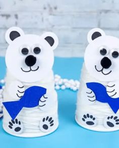 two white polar bears with blue ribbon on them