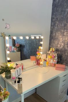 a white desk topped with a mirror and lots of lights on the top of it