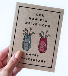 someone holding up a card with two golf bags on it that says, look how far we've come happy anniversary