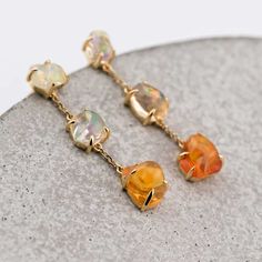 Unique Drop Earrings with Mexican Fire Opal 18K Yellow Gold. Free Domestic USPS First Class Shipping! Free One Year Limited Warranty! Free Gift Bag or Box with every order! Opal—the queen of gemstones, is one of the most beautiful and rarest gemstones on earth. Every piece of opals has its colors and patterns, which is perfect for designers to create unique engagement rings for someone extra special. We use 100% Natural & Ethical opal stones (NO synthetics or imitations) for our jewelry. --------------------------------------------------------------- ABOUT THIS PRODUCTSolid 18k Yellow GoldMexican Fire Opal: 3.74 ctMetal Color: Golden Opal Color: Rainbow ColorsEarring Size: 30x5 mm Occasion: Engagement / Wedding-------------------------------------------------------------------------------- Luxury Multi-stone 14k Gold Earrings, Exquisite Multi-stone Yellow Gold Earrings, Exquisite Yellow Gold Multi-stone Earrings, Luxury Multi-stone Gold Earrings, Luxury Multi-stone Earrings As Gift, Luxury Multi-stone Earrings Gift, Luxury Multi-stone Earrings For Gift, Fusion Style Multi-stone Yellow Gold Earrings, Yellow Gold Multi-stone Fusion Earrings