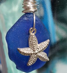 a starfish charm hangs on a blue sea glass bead