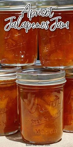 jars filled with apricot jalapenos jam sitting on top of a table