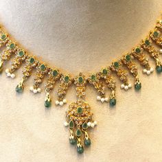 A lovely decorative piece featuring faceted and cabochon emerald drops, natural seed pearls and a plethora of diamonds! They are all set in 22k yellow gold giving the necklace a bright yellow color.    Length: 15.5 inches    Weight: 38.3 grams Traditional Emerald Necklace For Anniversary, Traditional Gold Necklaces With Rose Cut Diamonds, Traditional Gold Necklace With Rose Cut Diamonds, Green Temple Jewelry Necklace For Anniversary, Traditional Gold Emerald Necklace With Jewels, Traditional Emerald Necklaces For Anniversary, Festive Yellow Gold Emerald Necklace With Gemstone, Green Diamond Temple Jewelry Necklace, Wedding 22k Gold Emerald Necklace