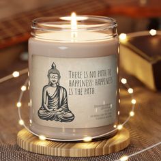 there is no path to happiness happiness is the path candle on a wooden stand with fairy lights around it