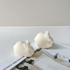 two white plastic mouses sitting on top of a piece of paper next to each other