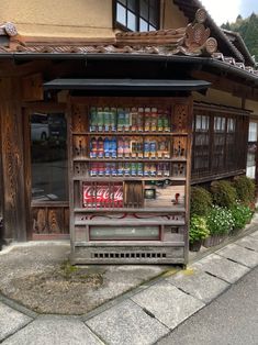 an old wooden store with soda cans on display