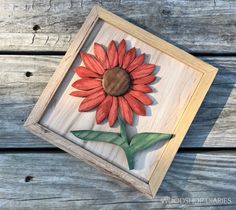 a wooden frame with a painted sunflower on it