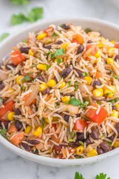 a white bowl filled with mexican rice salad and garnished with cilantro