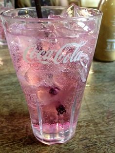 a glass filled with pink liquid sitting on top of a table