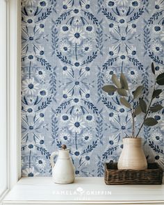 a vase with a plant in it sitting on a shelf next to a wallpaper