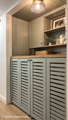 a kitchen with cabinets and cupboards on the wall next to a light fixture hanging above it