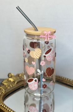 a glass with a straw in it sitting on a tray next to a gold frame