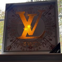 the louis vuitton logo is lit up in front of a window