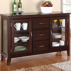 a wooden buffet table with glass doors and drawers