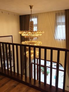 a chandelier hanging from the side of a stair case next to a window