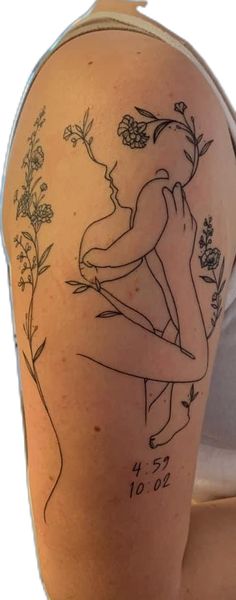 a woman's arm with a tattoo on it that has flowers and two women kissing each other