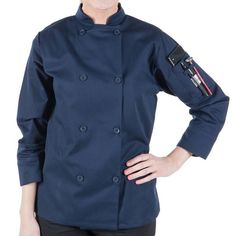 a woman wearing a blue chef coat with pockets on the front and side, smiling at the camera