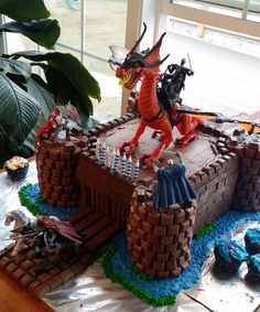 a cake made to look like a castle with two dragon figurines on top