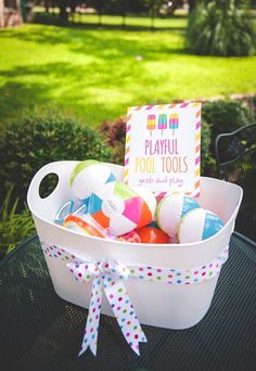 a white bucket filled with lots of colorful balls