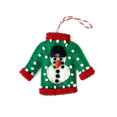 an ornament shaped like a sweater with a snowman on it