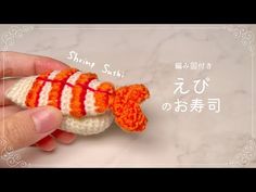 someone is holding a small crocheted fish in their hand