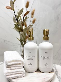 two bottles of hand soap on a marble tray