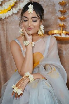 a woman with flowers in her hair sitting down