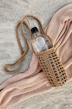 an empty bottle sitting on top of a blanket next to a towel and water bottle