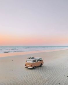 an old vw van is parked on the beach at sunset, with its roof down