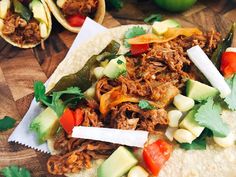 shredded meat and vegetables on top of tortillas