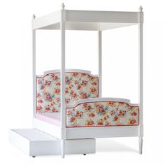 a white four poster bed with flowers on the headboard and foot board, sitting against a white background