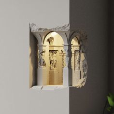 an arch in the wall with statues on it and a potted plant next to it