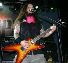 a man with long hair playing an electric guitar