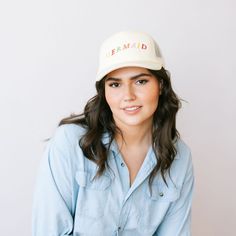 Make a splash in our Mermaid Embroidered Trucker Hat! This cream hat features playful, rainbow embroidered letters, adding a whimsical touch to your beach day look. Embroidered Baseball Cap For Beach, Playful Adjustable Cream Hat, Cream Trucker Hat For Summer Beach, Summer Beach Embroidered Trucker Hat, Embroidered Snapback Trucker Hat For Beach, Playful Trucker Hat With Curved Brim, Trendy Embroidered Beach Hat, Cream Curved Brim Trucker Hat For Beach, Cream Trucker Hat For Beach With Curved Brim